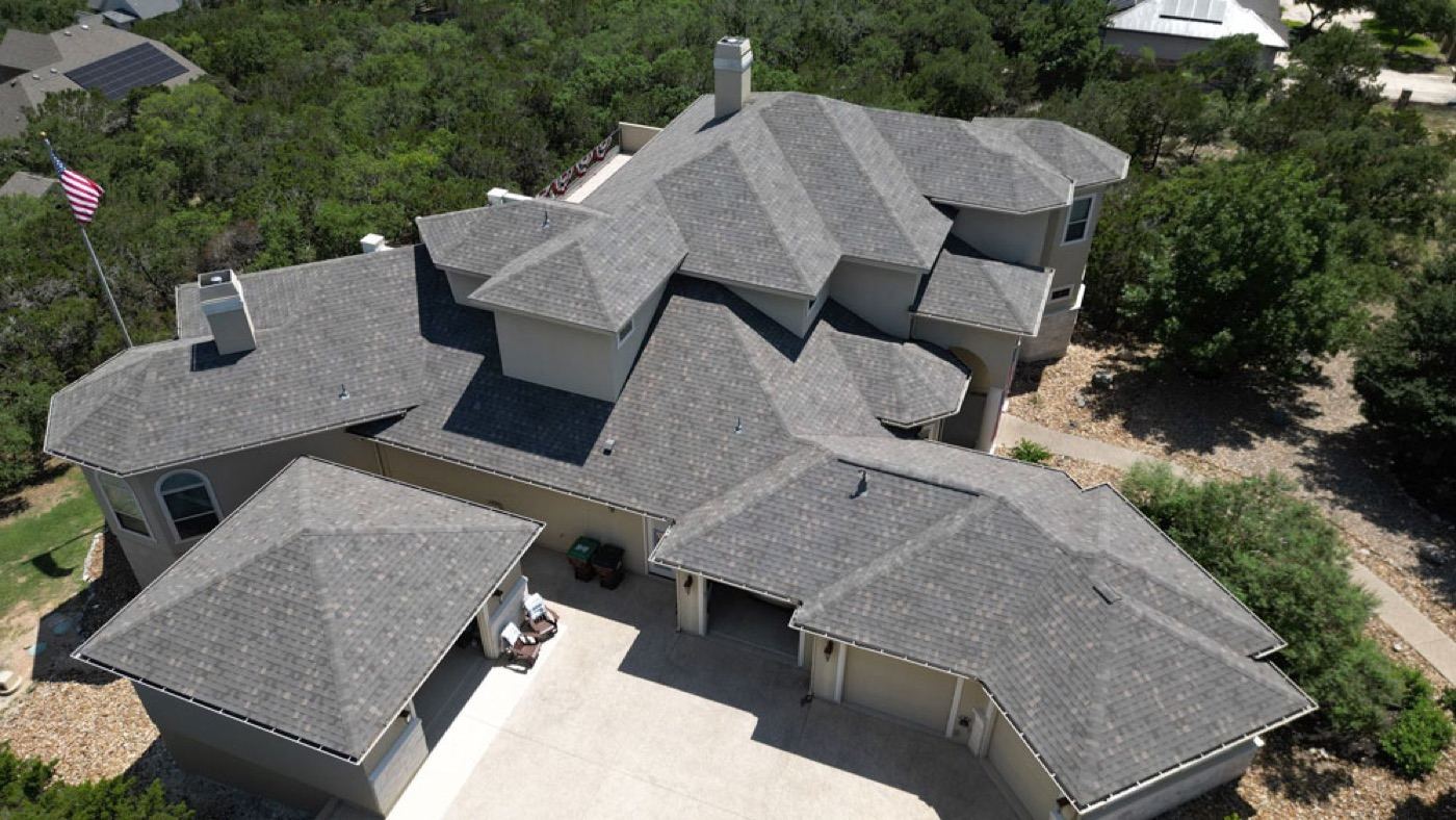 Aerial view of a completed multi-gable shingle roof replacement